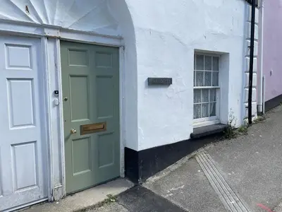 a green door on a white building with a window at The Locker, 2 bed apartment in Falmouth in Falmouth