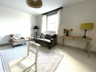 a living room with a couch and a chair at The Locker, 2 bed apartment in Falmouth in Falmouth