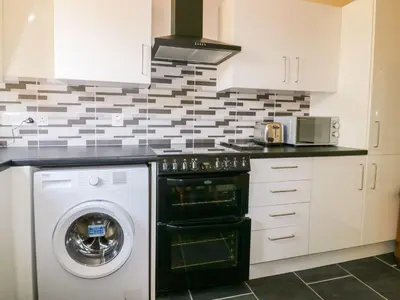 a kitchen with a washing machine and a washer at Camellia Cottage in Bodmin