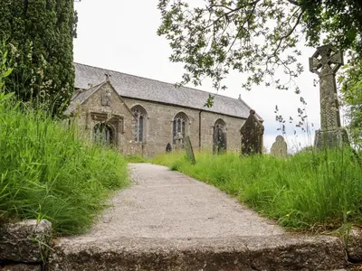 an old church with a dirt road in front of it at Lannlyvri Lodge in Bodmin