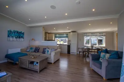 a living room with two couches and a table at Teal Lodge Cornwall - hot tub, indoor pool, near Perranporth in Cubert