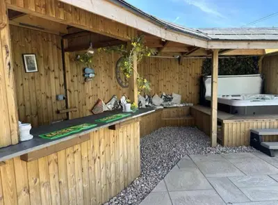 an outdoor kitchen in a wooden building at Private Retreat Hot Tub Fire Pit Patio Romantic in Morval