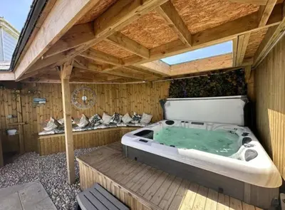 a large jacuzzi tub in a wooden building at Private Retreat Hot Tub Fire Pit Patio Romantic in Morval