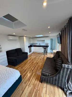 a living room with a bed and a couch and a kitchen at Private Retreat Hot Tub Fire Pit Patio Romantic in Morval