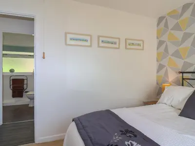a bedroom with a bed and a bathroom at Westview in Liskeard