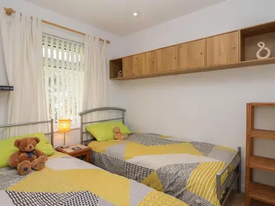 two beds in a bedroom with two teddy bears at Westview in Liskeard