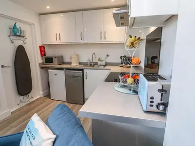 a kitchen with white cabinets and a counter top at Sea Whispers in Marazion