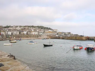 a group of boats in the water near a town at Sea Whispers in Marazion