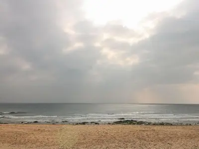 a beach with the ocean on a cloudy day at Sea Whispers in Marazion