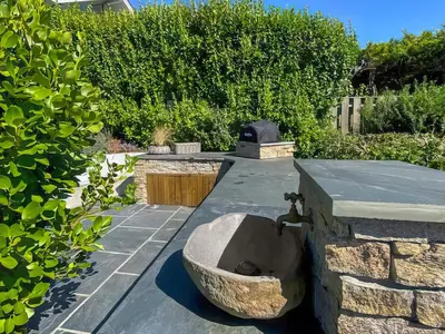 a stone sink sitting on top of a patio at Shearwaters in Truro