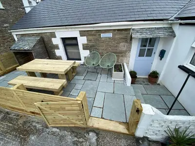 a patio with a table and chairs in front of a house at Blue Skies // Porth // Newquay in Newquay