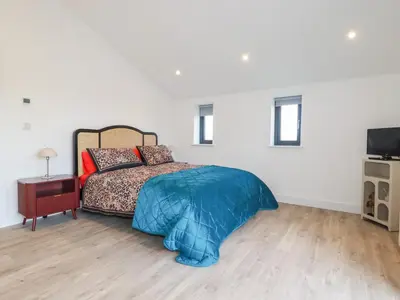 a bedroom with a bed and a television in it at Barn 5 in St Austell