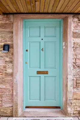 a blue door in a brick building with a wooden ceiling at The Quaker Hall - Private Deck - Stunning Views in Falmouth
