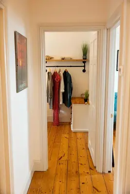 a hallway with a closet with clothes on hangers at The Quaker Hall - Private Deck - Stunning Views in Falmouth