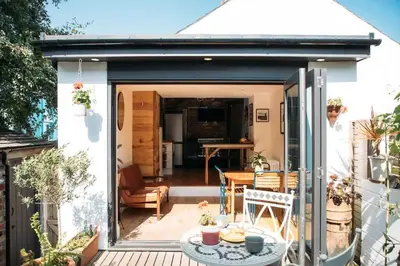 a small patio with a table on a deck at 'Langton' - Best Views in Falmouth! in Falmouth