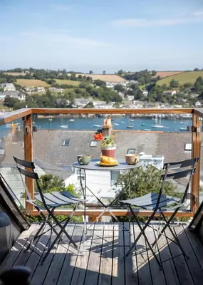 a patio with a table and chairs on a balcony at 'Langton' - Best Views in Falmouth! in Falmouth