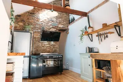 a kitchen with a stone wall and a stove at 'Langton' - Best Views in Falmouth! in Falmouth
