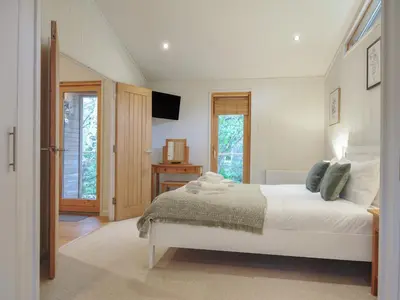 a bedroom with a bed and a television in it at 2 Streamside in Looe