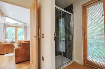 a living room with a glass door and a couch at 2 Streamside in Looe