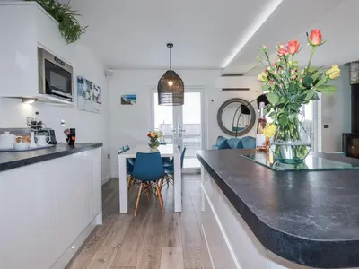 a kitchen with a counter with a vase of flowers on it at Adelaide in Redruth
