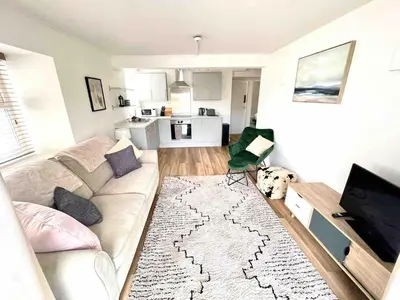 a living room with a couch and a dog at Minutes from the beach and town! in Falmouth