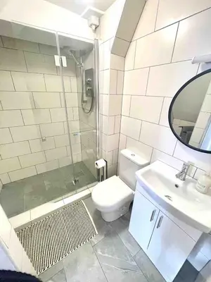 a bathroom with a shower and a toilet and a sink at Minutes from the beach and town! in Falmouth