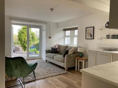 a living room with a couch and a kitchen at Minutes from the beach and town! in Falmouth