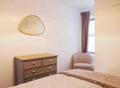 a bedroom with a mirror and a dresser and a chair at Minutes from the beach and town! in Falmouth