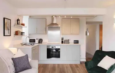 a living room with a couch and a kitchen at Minutes from the beach and town! in Falmouth