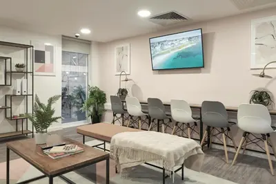 a waiting room with a long table and chairs at Contemporary Student-Only Apartments at The Quarry, Falmouth in Falmouth