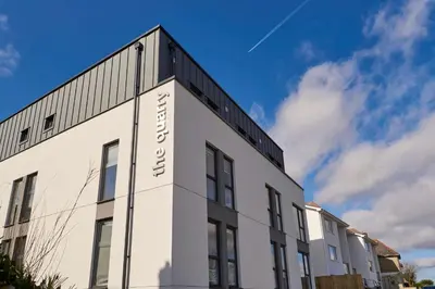 a white building with a sign on the side of it at Contemporary Student-Only Apartments at The Quarry, Falmouth in Falmouth