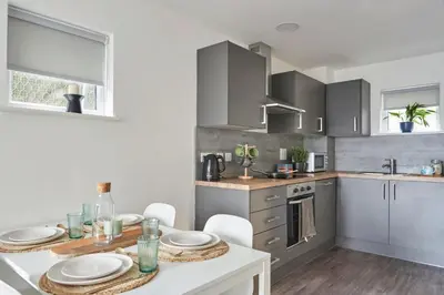 a kitchen with a table with white plates on it at Contemporary Student-Only Apartments at The Quarry, Falmouth in Falmouth