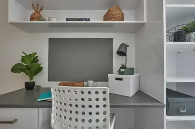 a room with a desk with a chair and a table at Contemporary Student-Only Apartments at The Quarry, Falmouth in Falmouth