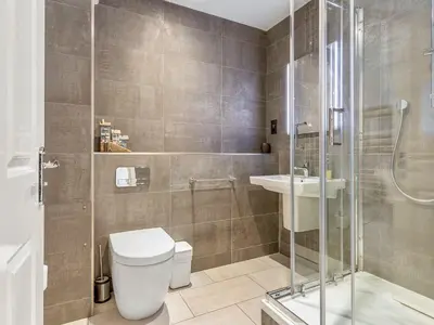 a bathroom with a shower and a toilet and a sink at Troy Court in Fowey