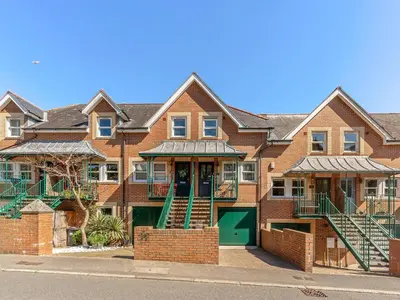 a brick apartment building with a green door at Troy Court in Fowey