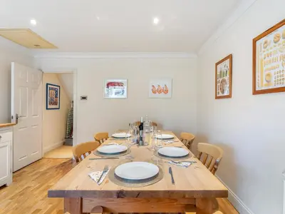 a dining room with a wooden table and chairs at Troy Court in Fowey