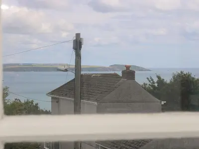a view of a house with a view of the water at Driftwood Cottage in St Austell