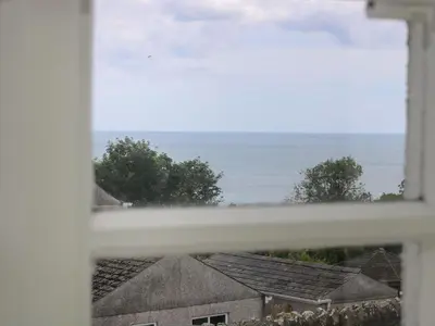 a view of the ocean from a window at Driftwood Cottage in St Austell