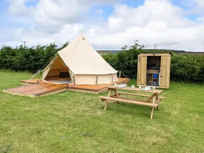 a tent and a picnic table in a field at I do glamping penhallow campsite Ltd in Truro