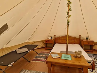 a room with a tent with a wooden table and a table sidx sidx sidx at I do glamping penhallow campsite Ltd in Truro