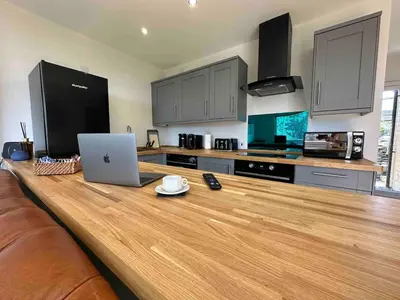 a kitchen with a table with a laptop on it at Seafell in Forrabury