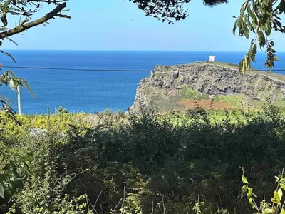 a lighthouse on top of a cliff near the ocean at Seafell in Forrabury
