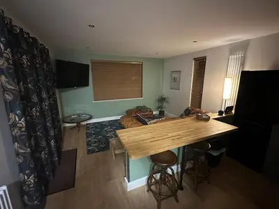a living room with a table and a couch at Seafell in Forrabury