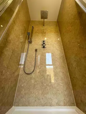 a bathroom with a shower with a hose on the floor at Seafell in Forrabury