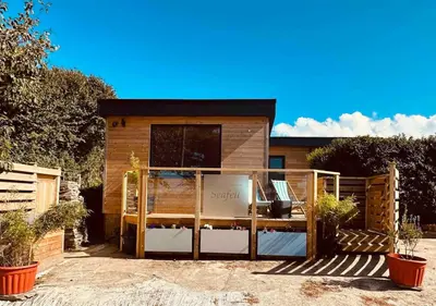 a house with a screened in porch in a yard at Seafell in Forrabury