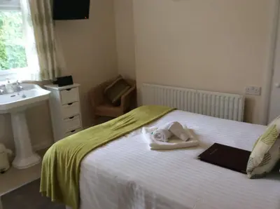 a bedroom with a bed with a sink and a book at Chy an Gwedhen in St Ives