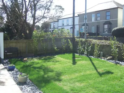 a backyard with a fence and a yard with green grass at Chy an Gwedhen in St Ives