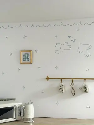a kitchen with a white wall with stickers on it at Heart of St Ives with parking - 2 bedrooms in St Ives