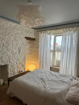 a bedroom with a large bed and a window at Heart of St Ives with parking - 2 bedrooms in St Ives