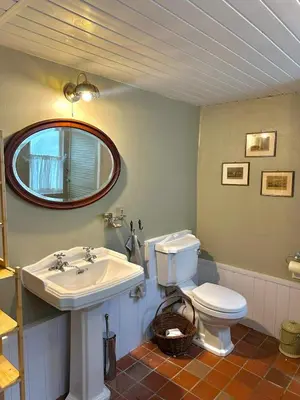 a bathroom with a sink and a toilet and a mirror at Heart of St Ives with parking - 2 bedrooms in St Ives